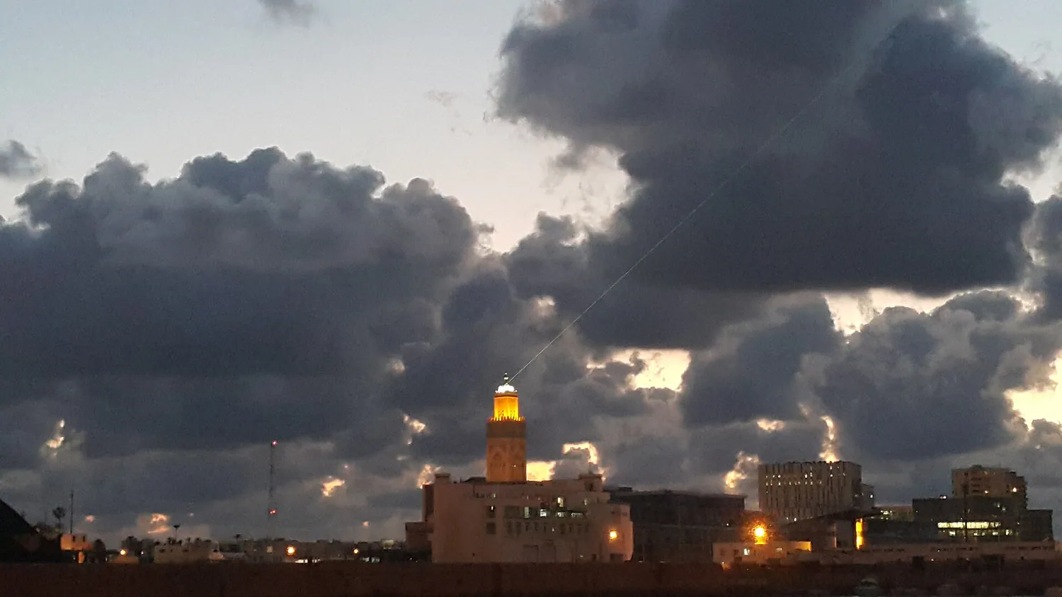 Opplyst minaret mot mørk kveldshimmel over Casablanca