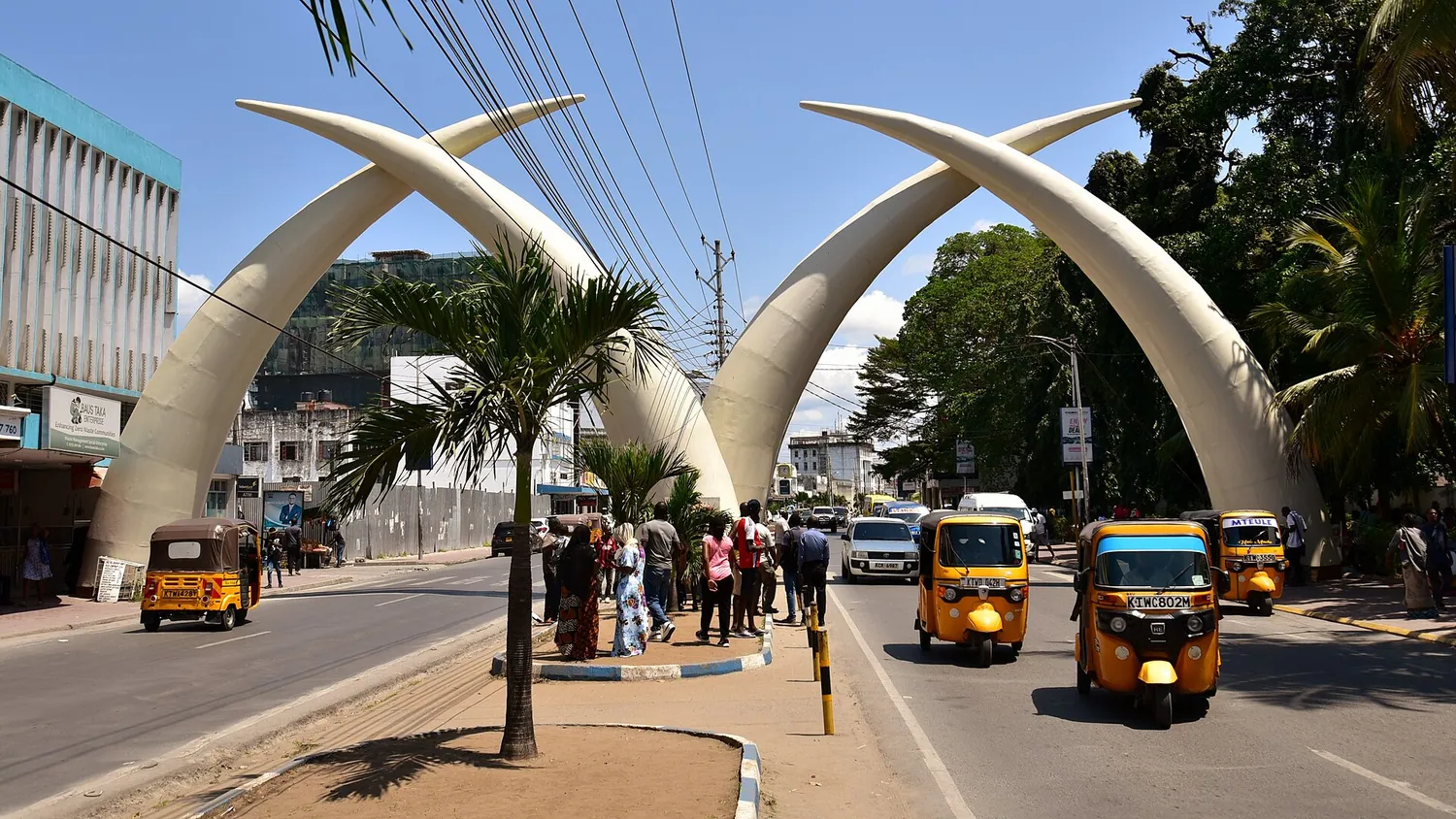 Støttennene over Moi Avenue i Mombasa med tuk-tuker i gaten under
