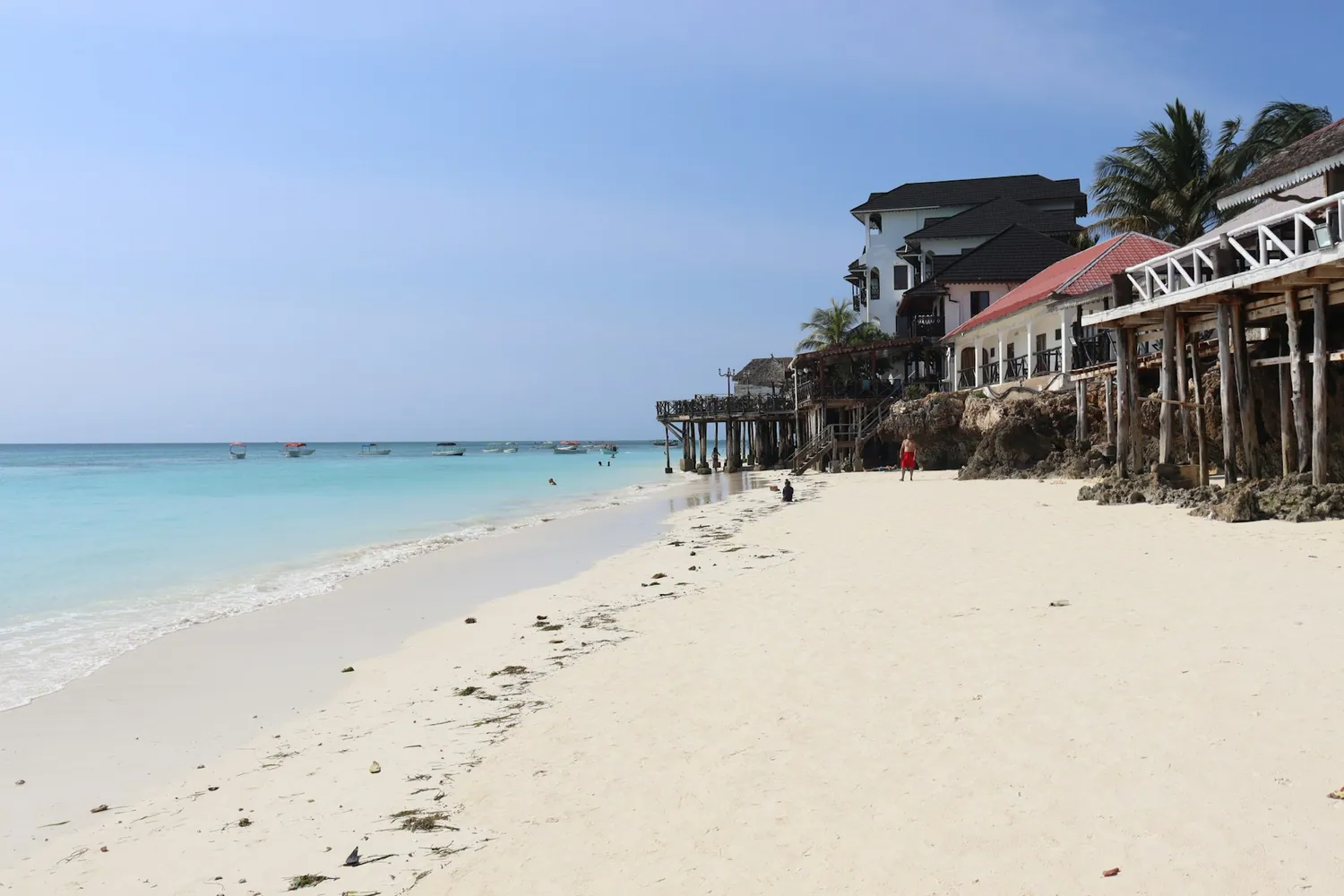 Hvit sandstrand med pælehus på Zanzibar