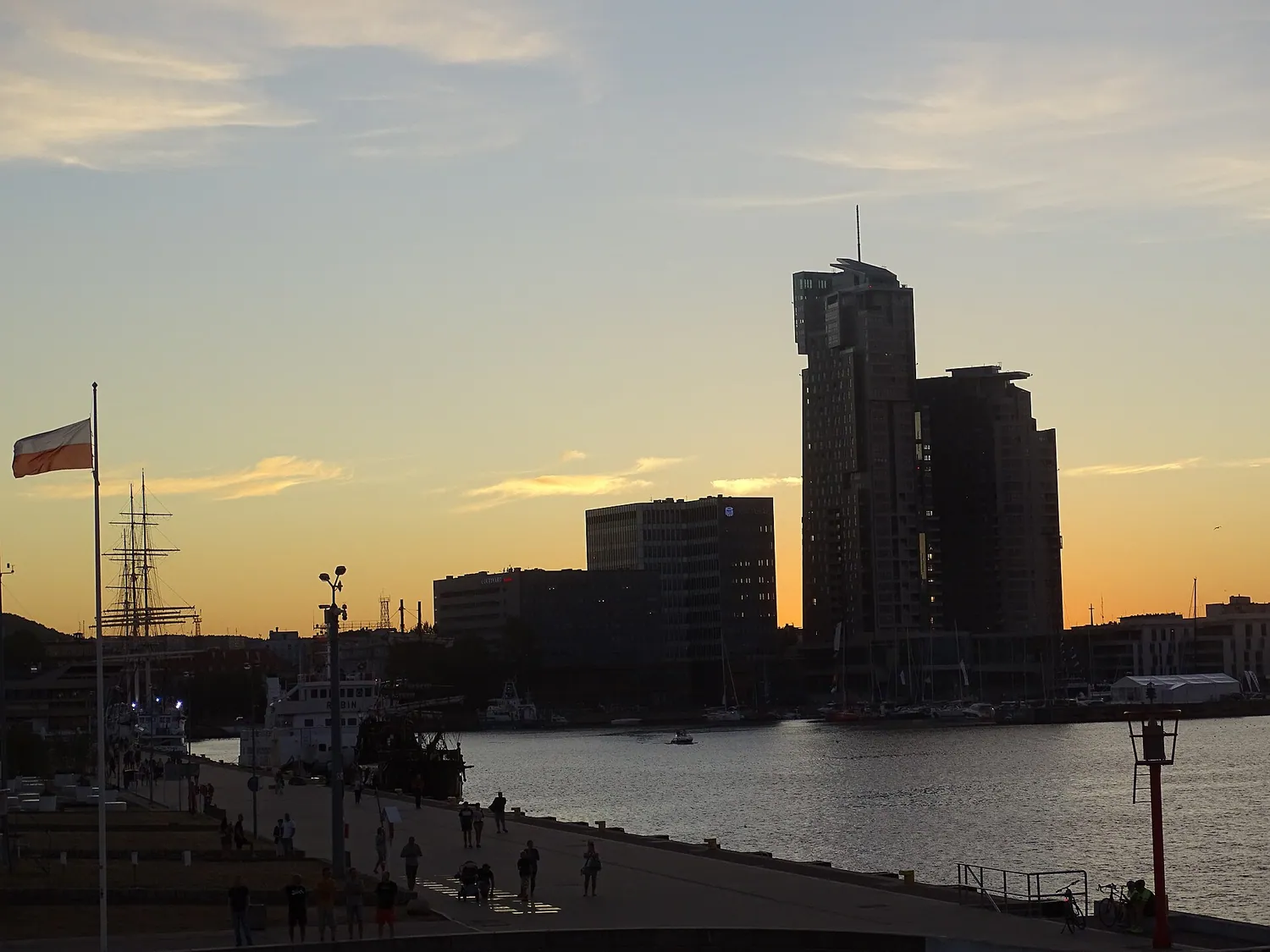 Havnen i Gdynia i solnedgang med byens høyhus i silhuett