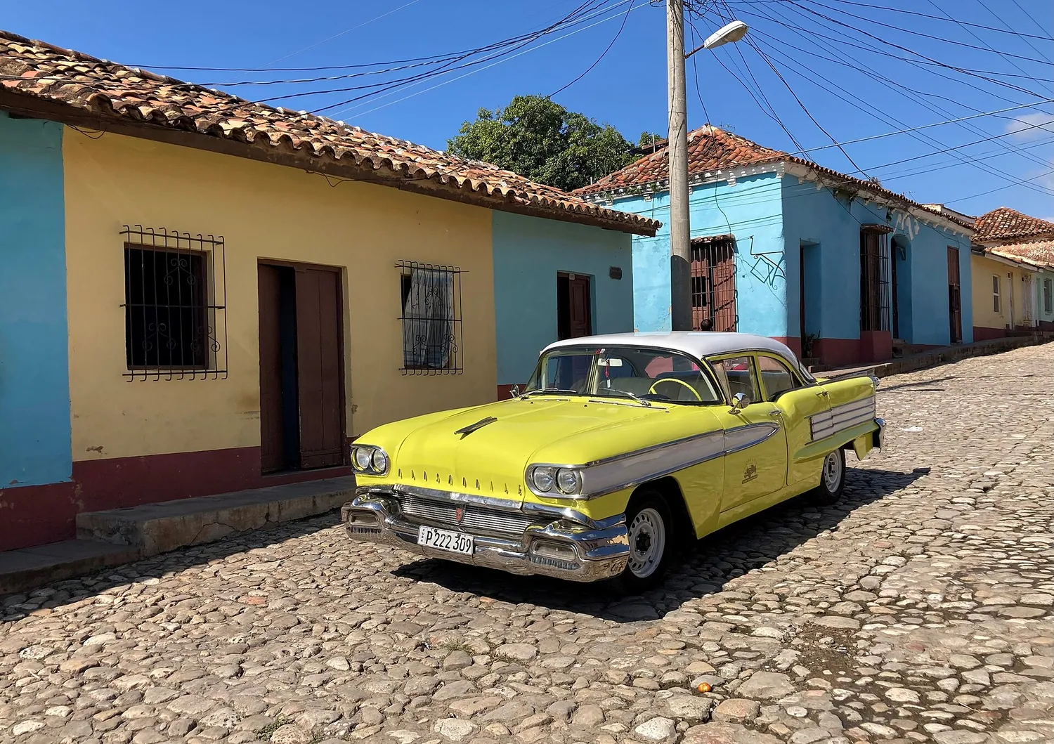 Gate i Trinidad på Cuba med en klassisk amerikansk bil