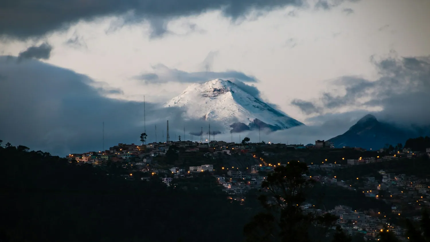Quito med Cotopaxi-vulkanen i morgengry